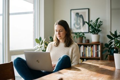 Femme détendue avec ordinateur dans appartement lumineux